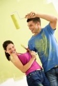 2043649-attractive-couple-standing-in-front-of-partially-painted-wall-playfully-putting-paint-on-eachother